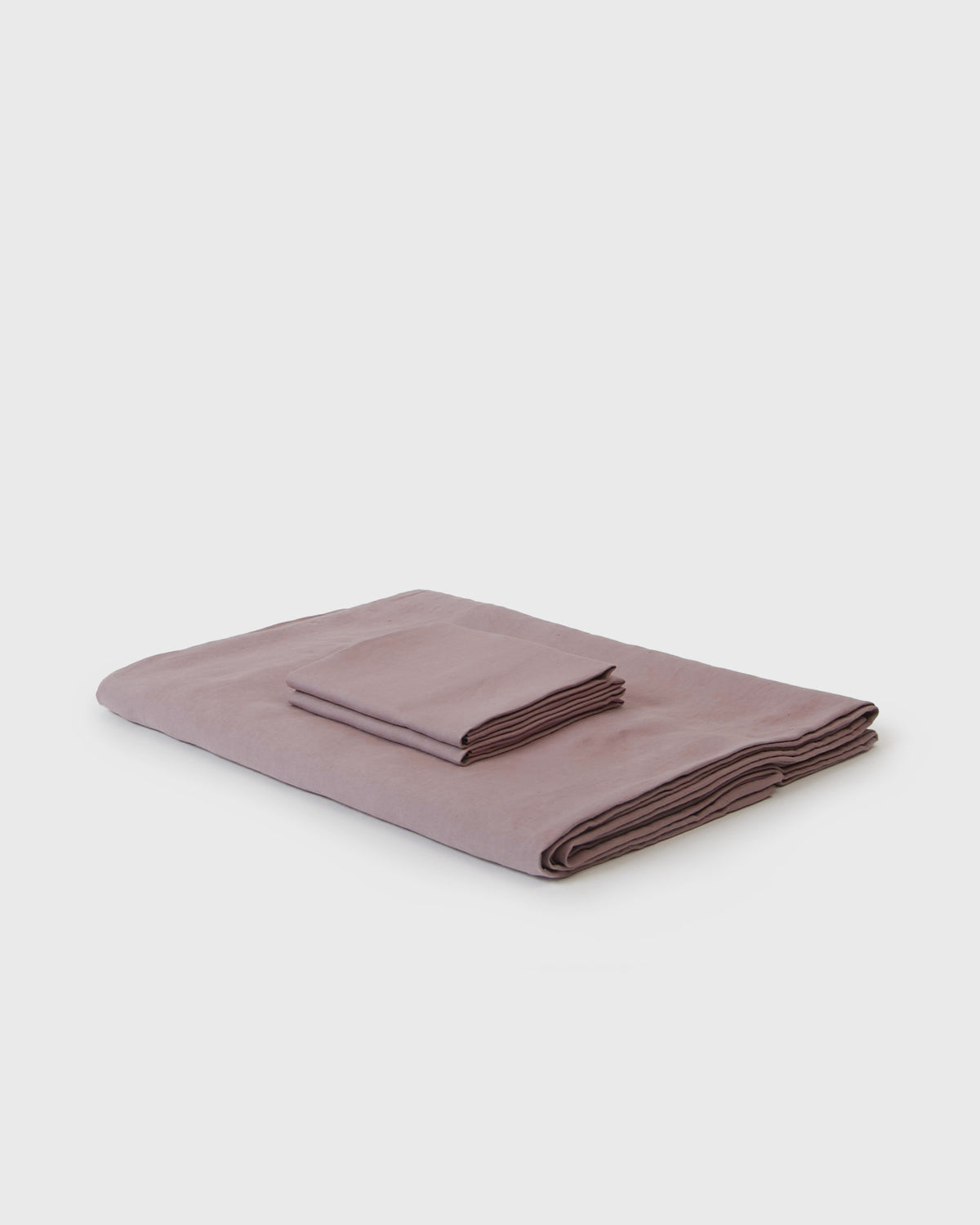 Side angle shot of linen duvet cover and pair of pillowcases in dark orchid pink