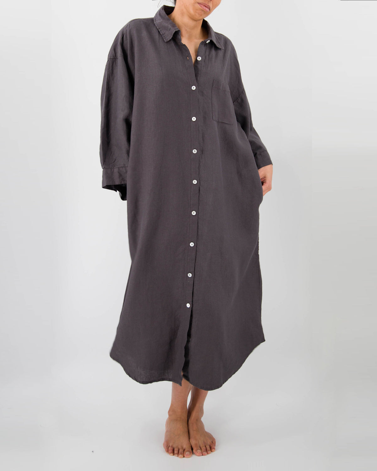 Front photo of model with full-length linen dress with buttons and front pocket in charcoal black