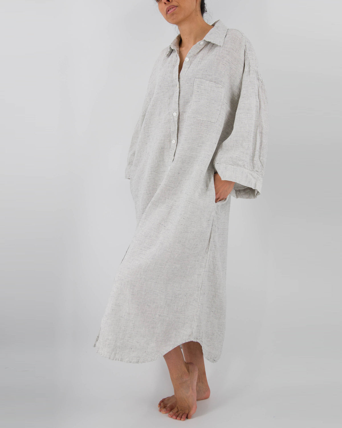 Front photo of model with full-length linen dress with buttons and front pocket in pinstripe