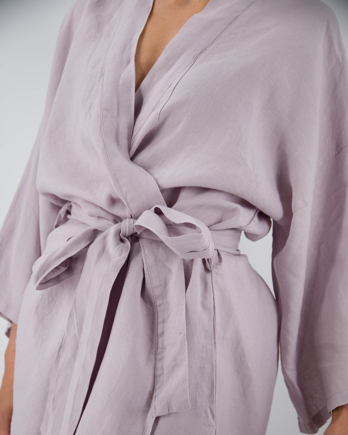 Close up of full-length linen robe in lilac purple on model