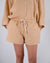 Apricot orange linen shorts with drawstring tie on model