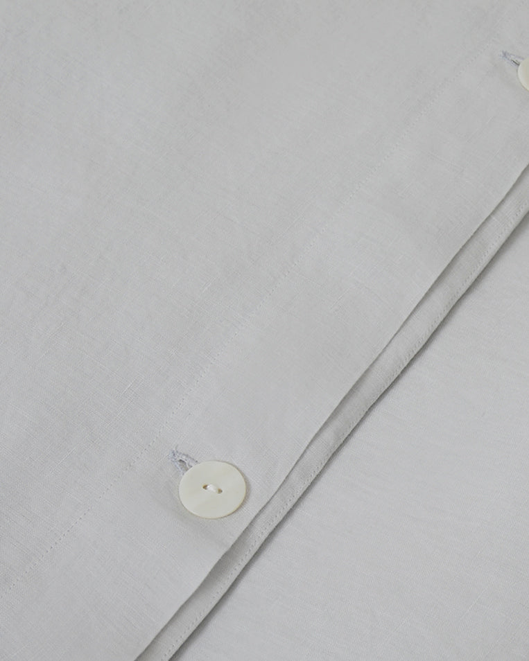 Close-up shot of light blue glacier linen duvet cover with mother of pearl button
