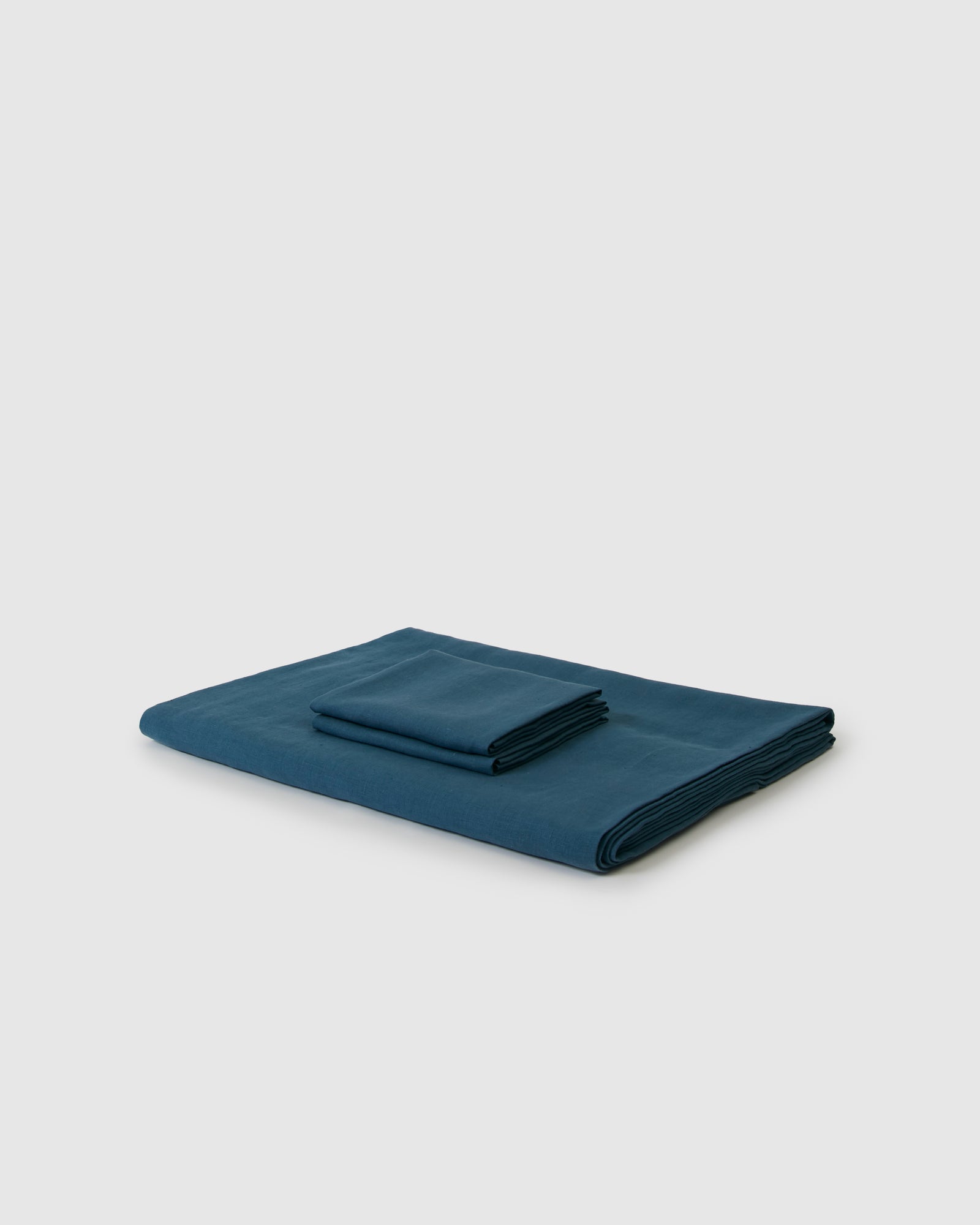 Side angle shot of linen duvet cover and pair of pillowcases in dark blue adriatic