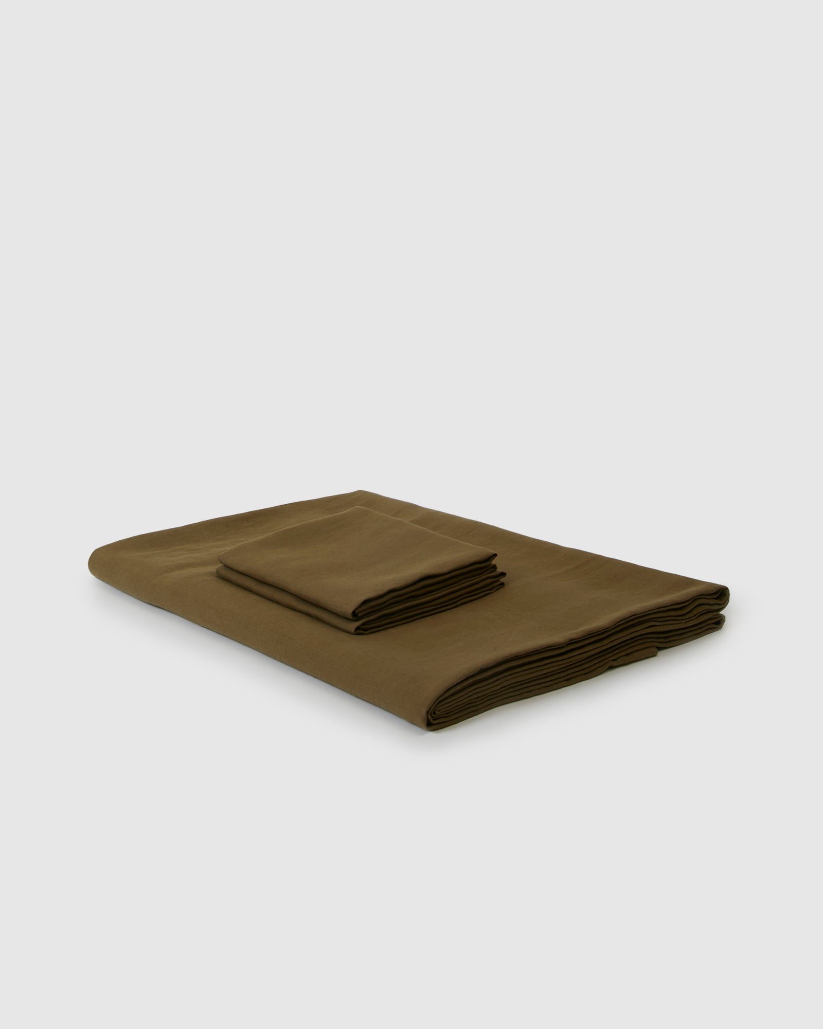 Side angle shot of linen duvet cover and pair of pillowcases in moss green