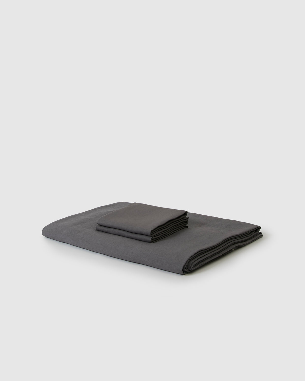 Side angle shot of linen duvet cover and pair of pillowcases in storm dark gray