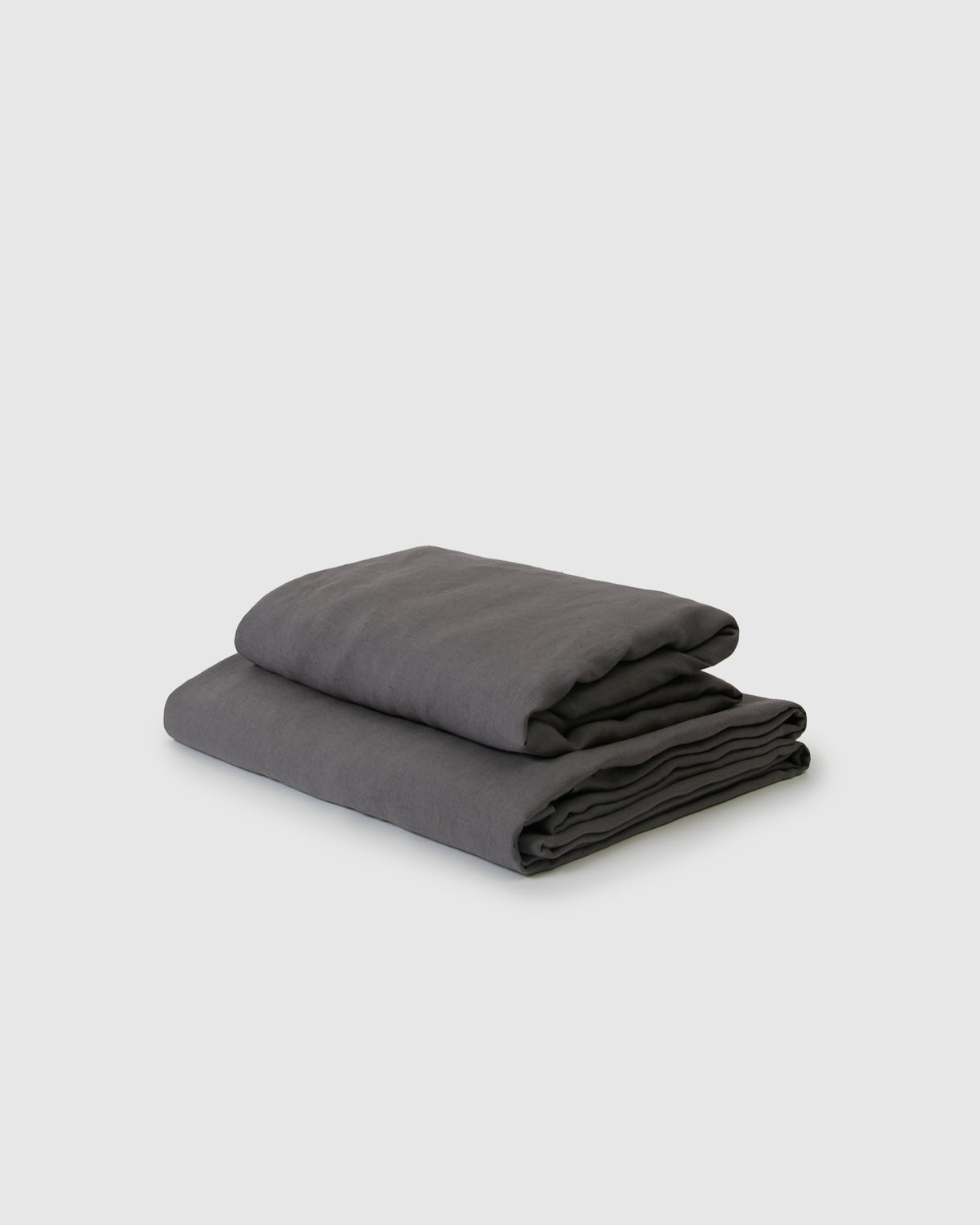 Side angle shot of dark gray storm flat and fitted sheet set