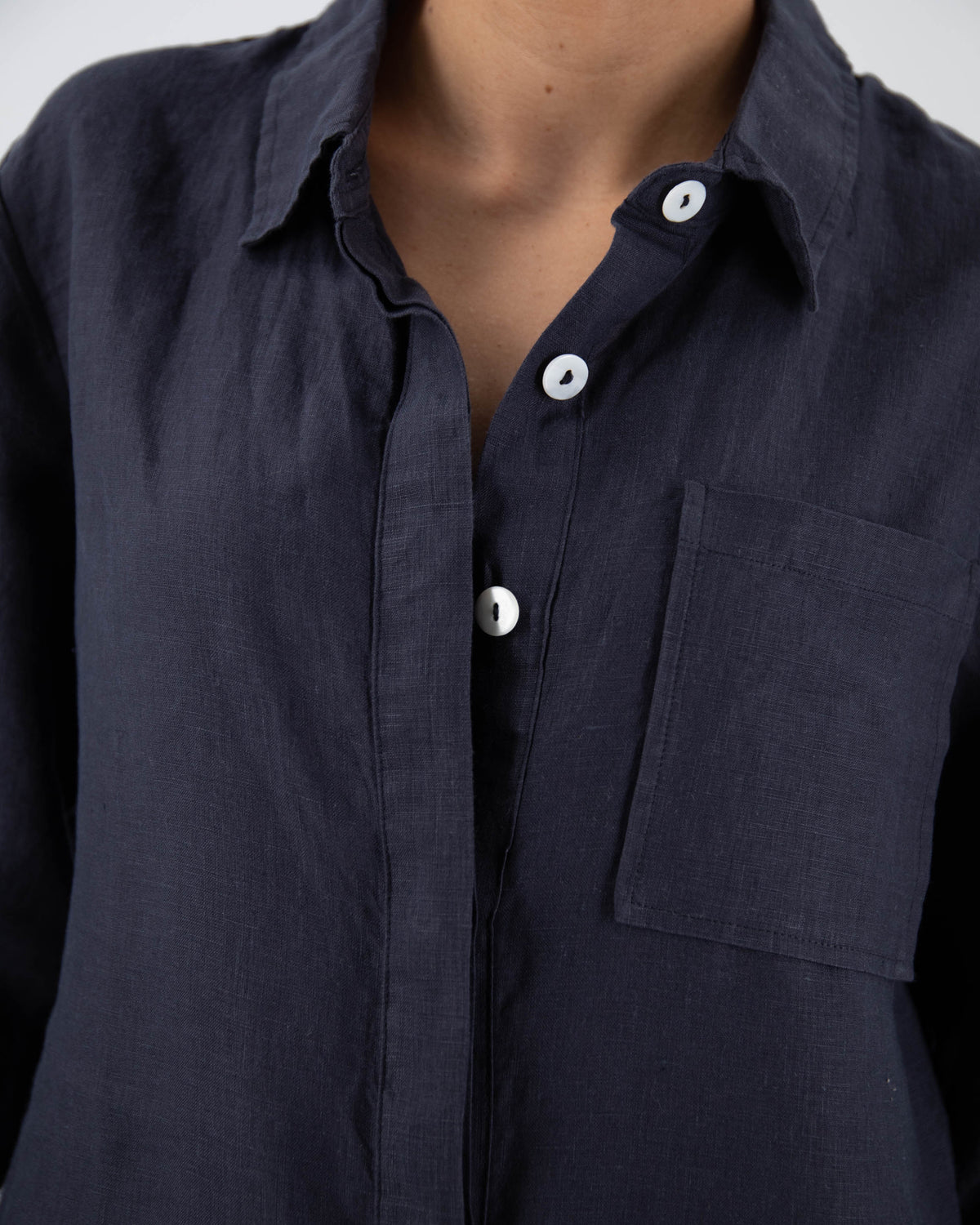 Close up of torso of model in midnight blue linen jumpsuit