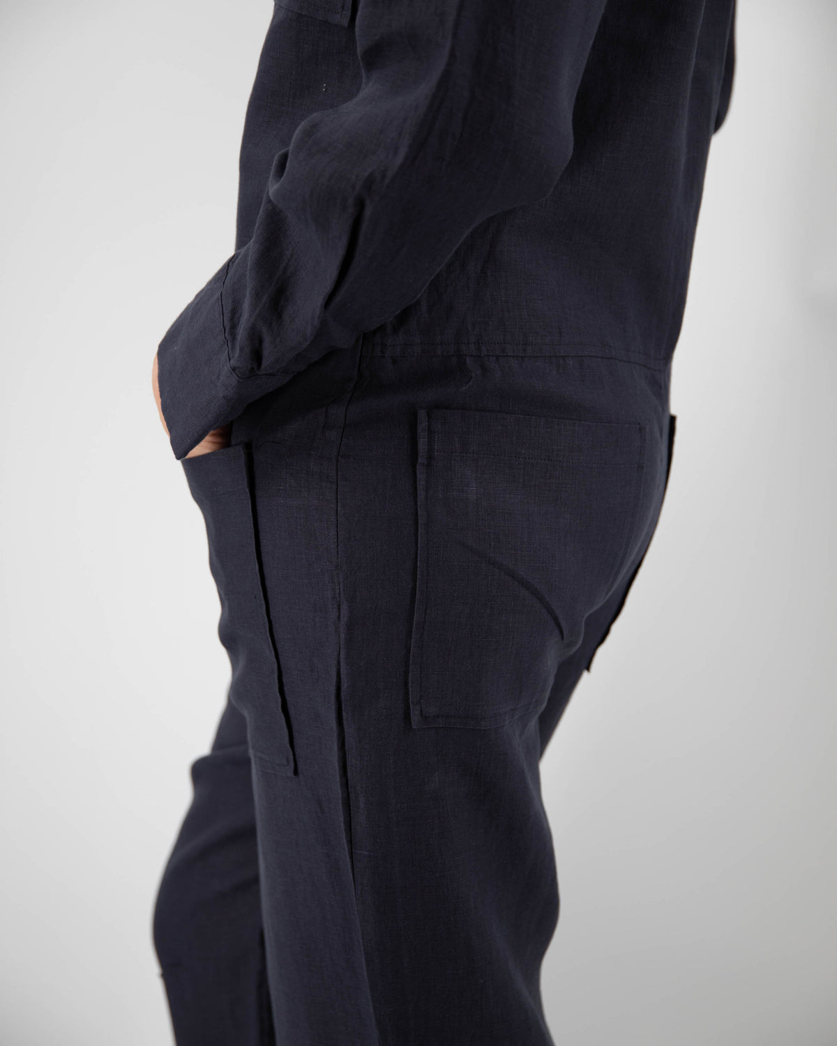 Close-up of front and back pockets of midnight blue linen jumpsuit