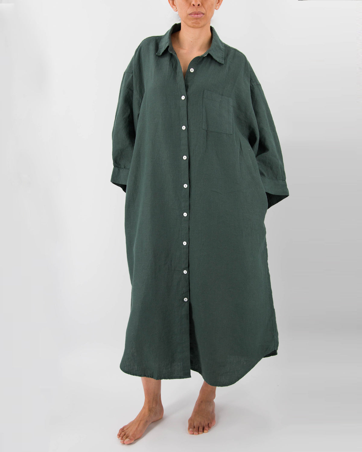 Front photo of model with full-length linen dress with buttons and front pocket in pine green 