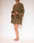 A person standing side-on wearing a green French linen short robe with billowing sleeves, tied at the waist.