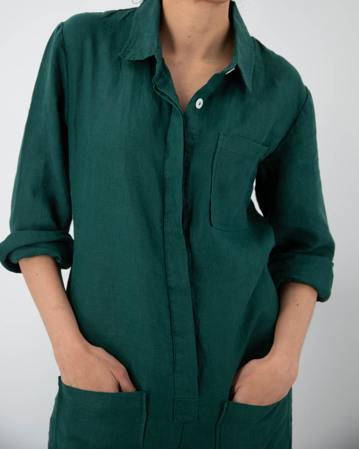 Close up of torso of model in botanical green linen jumpsuit