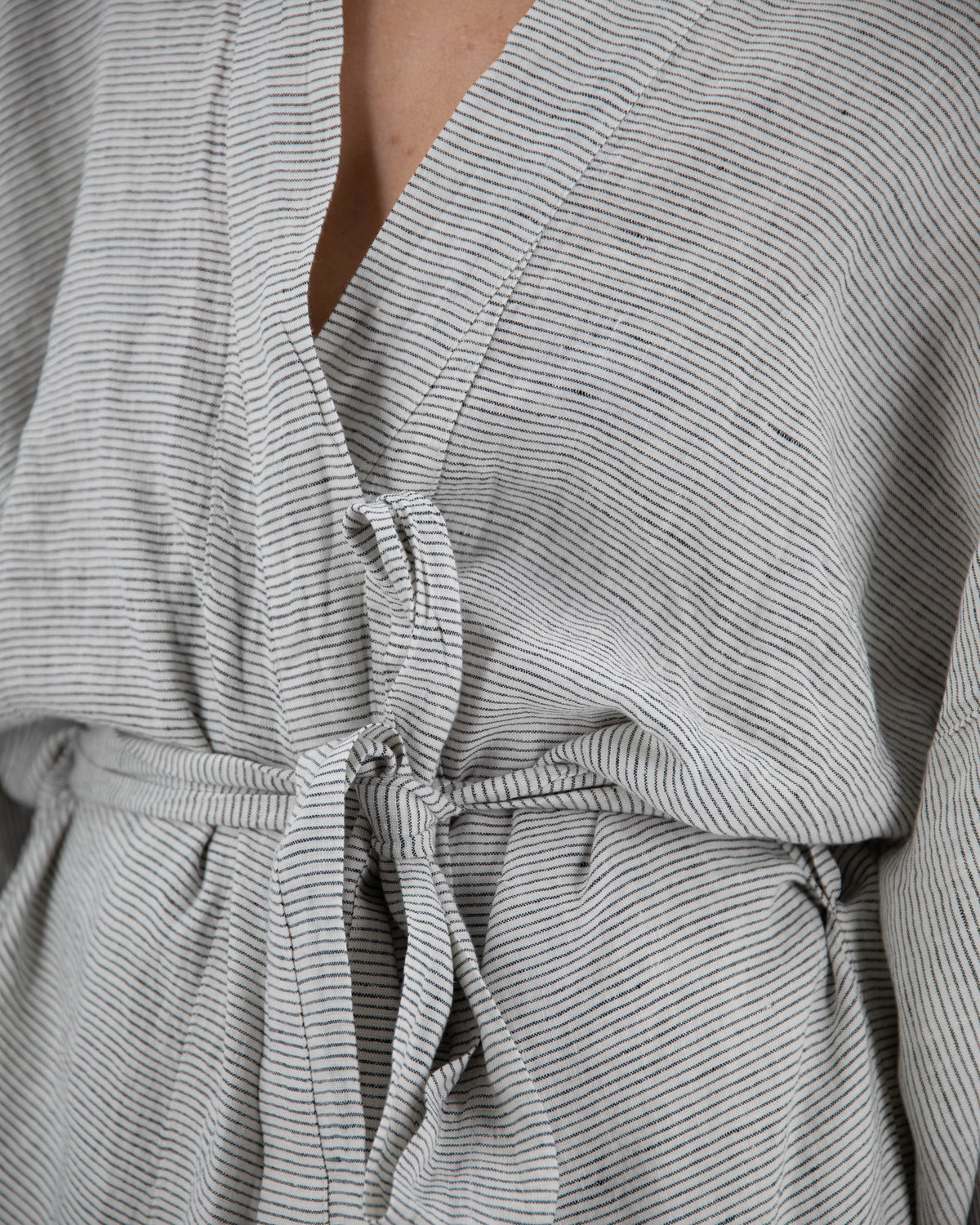 Close up of full-length linen robe in pinstripe pattern on model